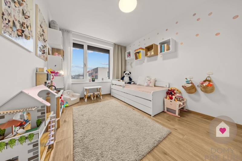 Kinderzimmer in einer 4-Zimmer-Wohnung mit Spielzeug, Bücherregal und Holzboden.