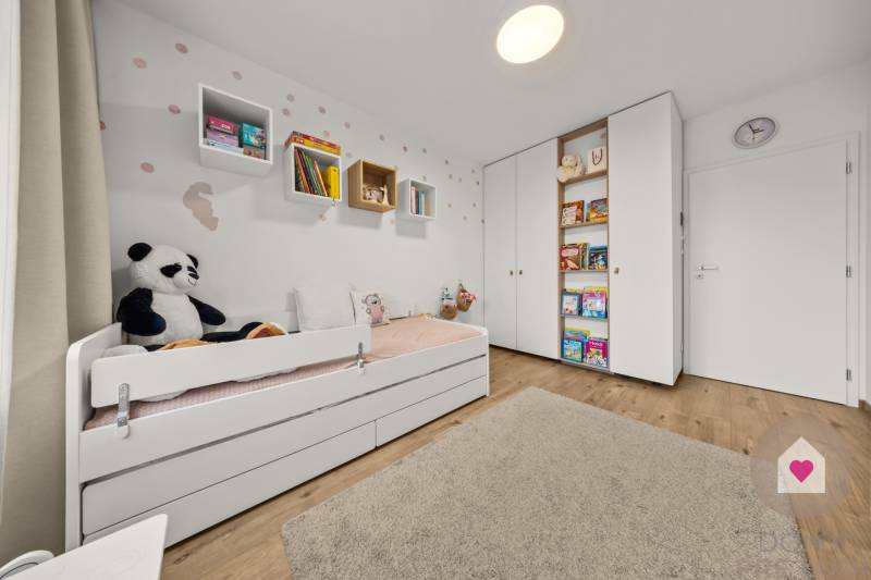 Kinderzimmer in einer Vierzimmerwohnung mit Bett, Spielzeug und Büchern, Boden mit Holzdekor.