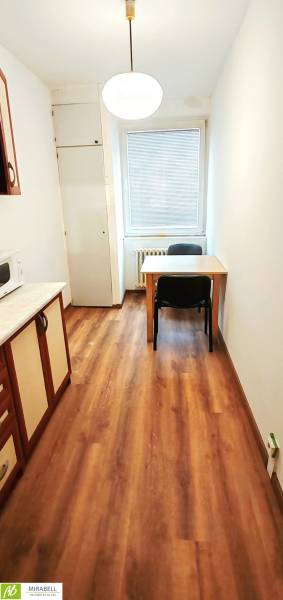 Küche in einer 3-Zimmer-Wohnung mit Holzboden und einem Tisch für zwei Personen.