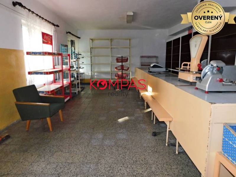 Innenraum eines Geschäftsraums mit Theke, Regalen und Sessel.