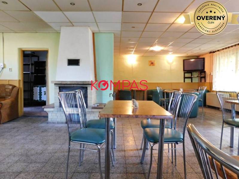 Gewerbeflächen mit stilvollen Stühlen, Tisch und Kamin, geeignet für Veranstaltungen.