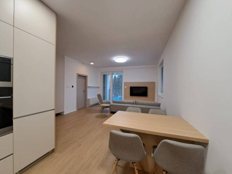 Wohnzimmer in einer 2-Zimmer-Wohnung mit Holzboden und offener Küche.