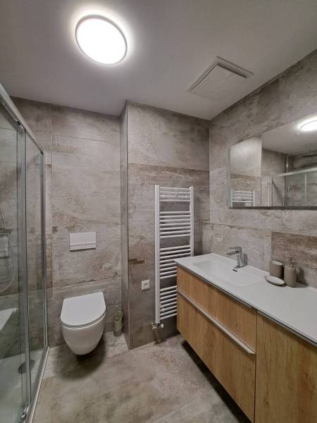 Badezimmer in einer 2-Zimmer-Wohnung mit moderner Sanitäranlage und Wänden mit grauem Muster.