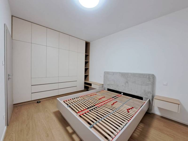 Schlafzimmer in einer 2-Zimmer-Wohnung mit Holzboden und Einbauschrank.