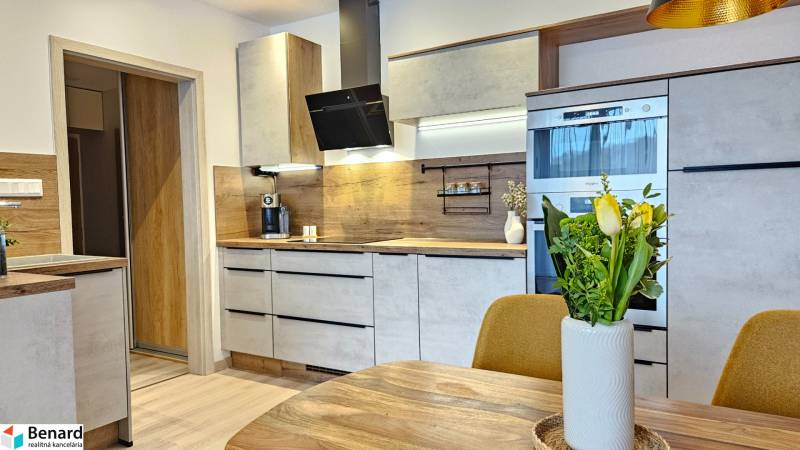 Küche in einer Einzimmerwohnung mit Holzdekorboden und moderner Ausstattung.