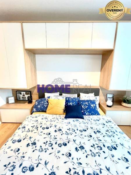 Schlafzimmer in einer 3-Zimmer-Wohnung mit Holzboden und Blumendekoration.