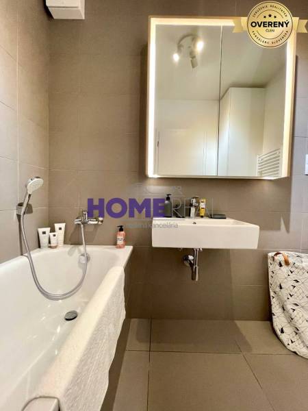 Badezimmer mit Badewanne und Spiegel in einer 3-Zimmer-Wohnung.