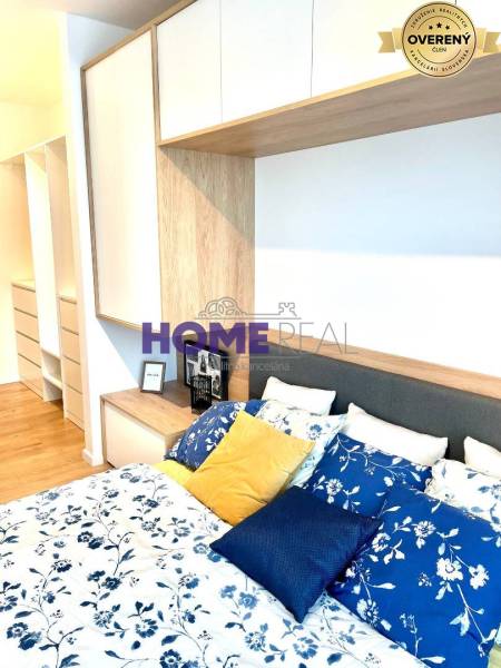 Schlafzimmer in einer 3-Zimmer-Wohnung mit Bett, bunten Kissen und Stauraum.