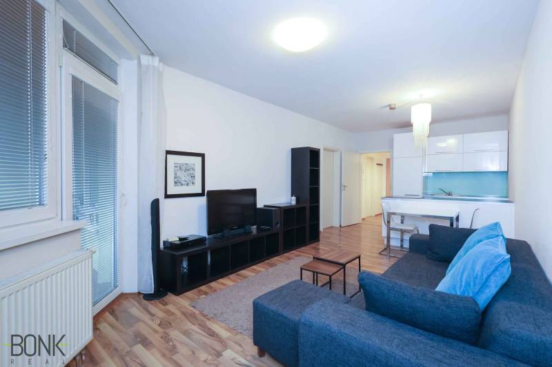 Wohnzimmer einer 2-Zimmer-Wohnung mit Holzboden und stilvollen Möbeln.