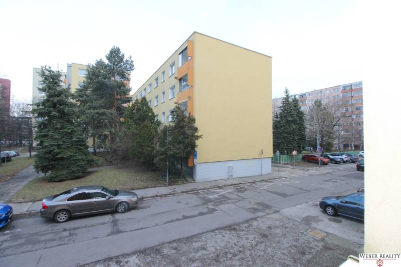 Ein Wohnhaus in Bratislava in der Cabanova-Straße in einer Umgebung mit Nadelbäumen.