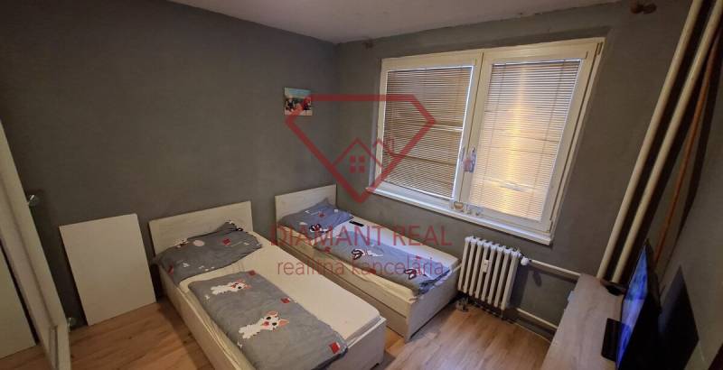 Kinderzimmer in einer 3-Zimmer-Wohnung mit zwei Betten und einem Boden in Holzoptik.