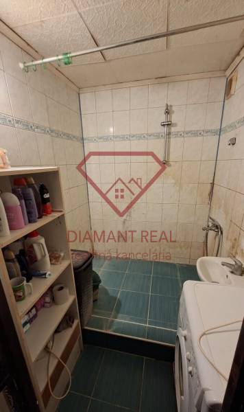 Gemütliches Badezimmer mit Waschmaschine, weißen Fliesen und Regalen, ideal für eine 3-Zimmer-Wohnung.