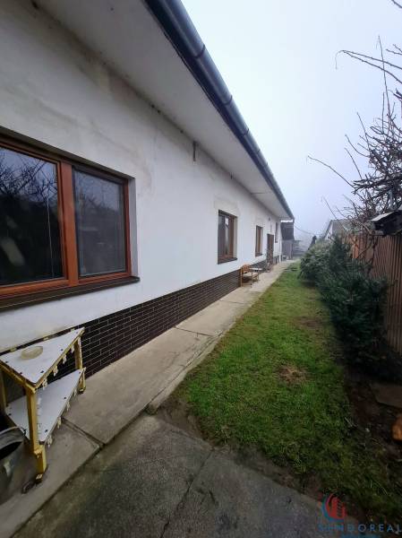 Ein Einfamilienhaus am Platz des 1. Mai in Chtelnica mit einem seitlichen Gehweg und einem Garten.