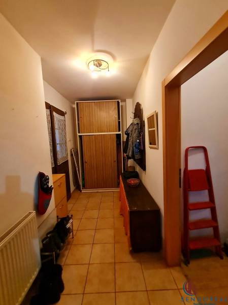 Flur in einem Einfamilienhaus mit Fliesen, Schuhschrank, Garderobe und Schrank.