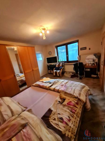 Schlafzimmer mit Bett, Schrank und Tisch in einem Einfamilienhaus.