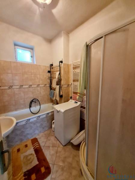 Badezimmer mit Badewanne, Dusche und Waschmaschine in einem Einfamilienhaus.