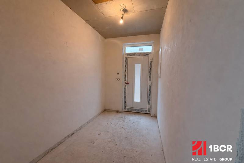 Ein Flur in einem Einfamilienhaus mit einfacher Beleuchtung und Kunststofftüren.