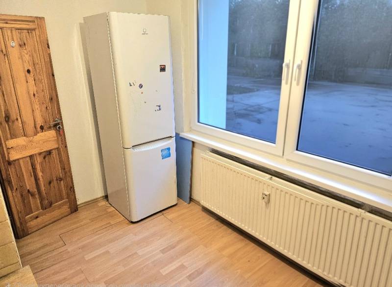 Küchenzeile in einer 3-Zimmer-Wohnung mit Gerät und Boden in Holzoptik.