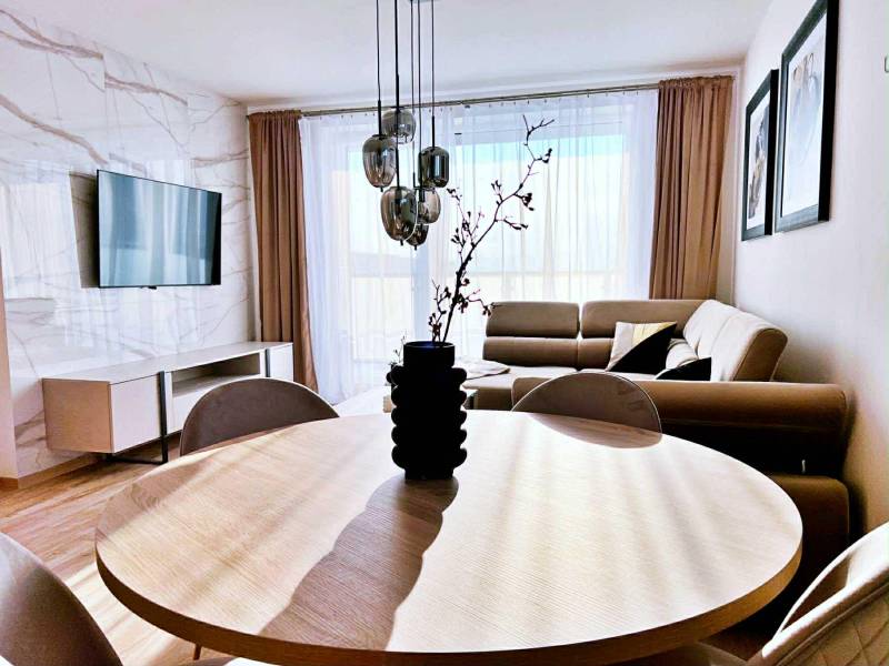 Wohnzimmer in einer 3-Zimmer-Wohnung mit Holzboden und bequemer Couch.