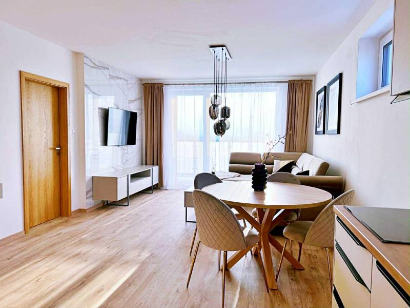 Wohnzimmer in einer 3-Zimmer-Wohnung mit hellen Möbeln und einem Boden in Holzoptik.