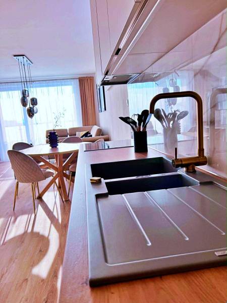 Küche in einer 3-Zimmer-Wohnung mit hellem Boden in Holzoptik und stilvollem Sitzbereich.