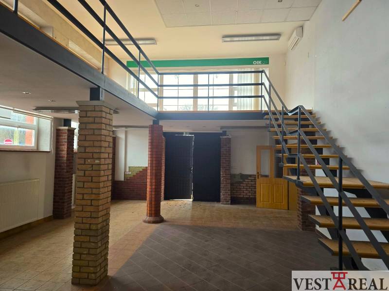Gewerbeflächen mit Holzboden und Treppe neben Backsteinsäulen.