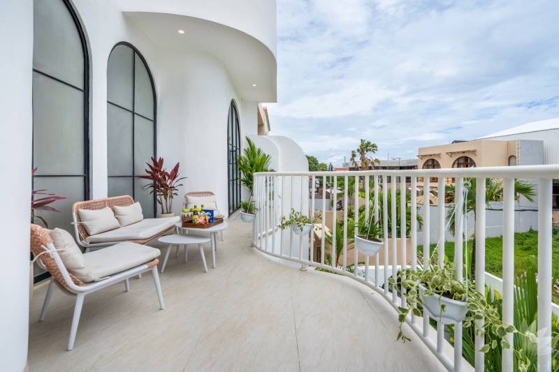 Geräumiger Balkon in einer Villa mit bequemen Sitzgelegenheiten, Pflanzen und Blick auf Berawa in Canggu.