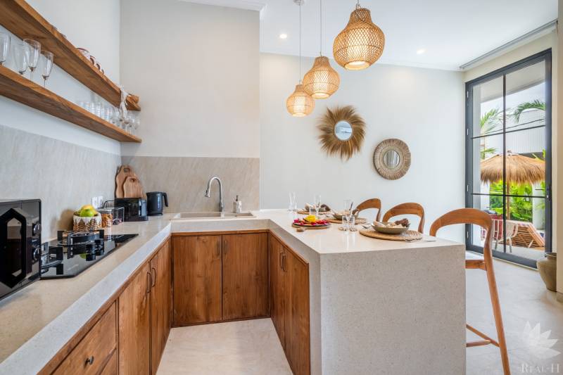 Innenraum der Villa mit Küchenzeile, Holzschränken und dekorativen Spiegeln.