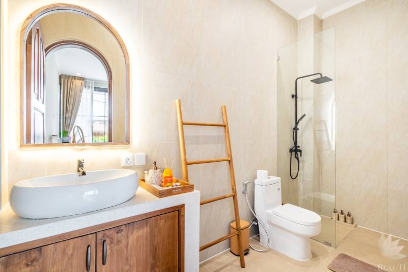 Badezimmer in der Villa mit Waschbecken, Dusche und Handtuchhalter in Leiterform.