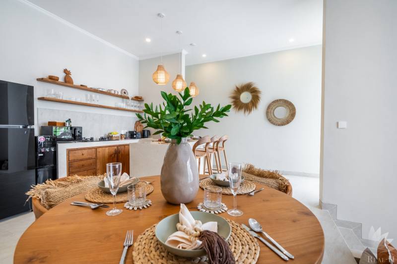 Ein gedeckter Tisch in einer Villa mit Holzdekorboden und Küchenzeile.