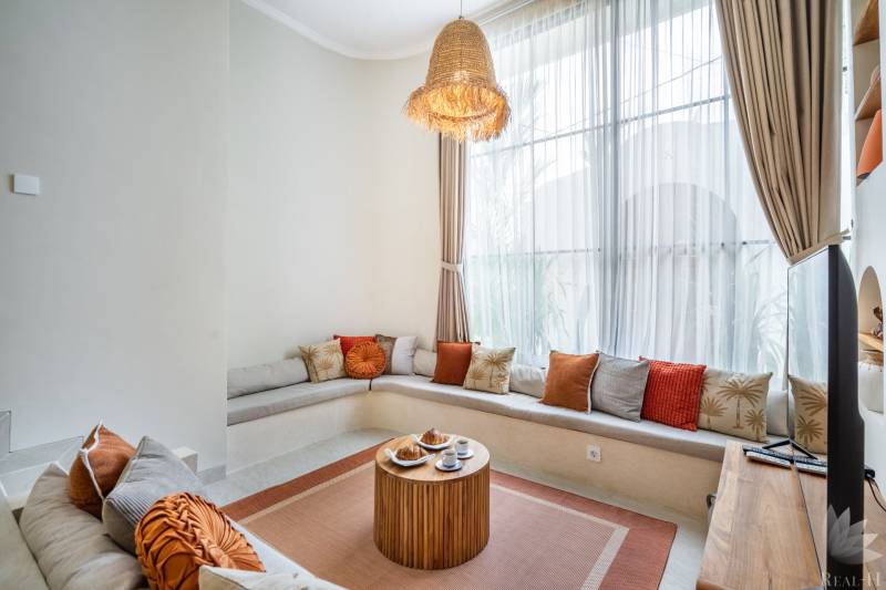 Bequeme Sitzgelegenheiten mit Kissen und einem Holztisch in einer gemütlichen Ecke der Villa.