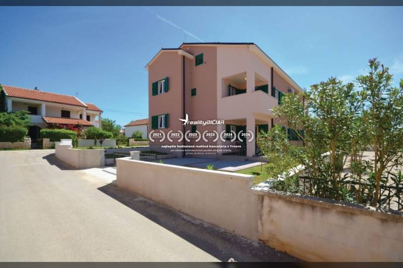 Eine 2-Zimmer-Wohnung in der Straße Privlaka in Privlaka, umgeben von grünen Büschen und benachbarten Häusern.