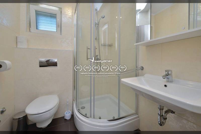 Badezimmer in einer 2-Zimmer-Wohnung mit Toilette, Dusche und Waschbecken.