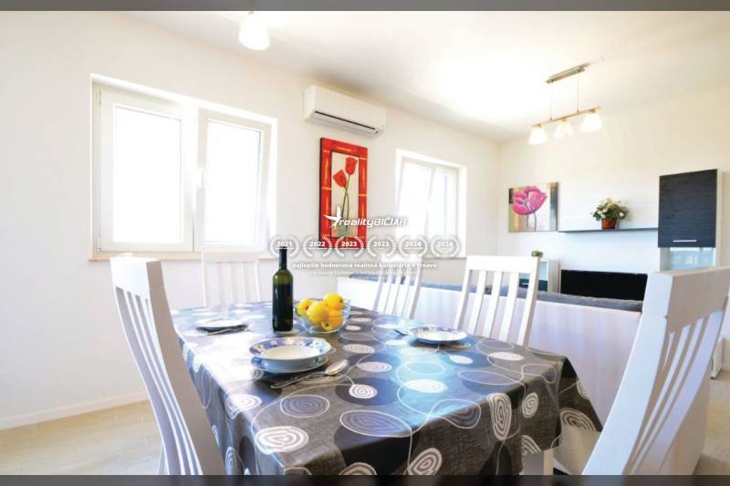 Essbereich in einer 2-Zimmer-Wohnung mit gedecktem Tisch und Wanddekorationen.