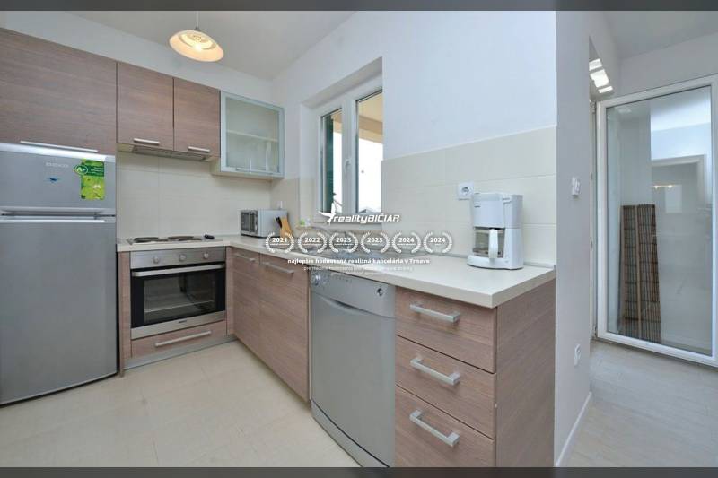 Küche in einer 2-Zimmer-Wohnung mit Ausstattung und Boden in Holzoptik.