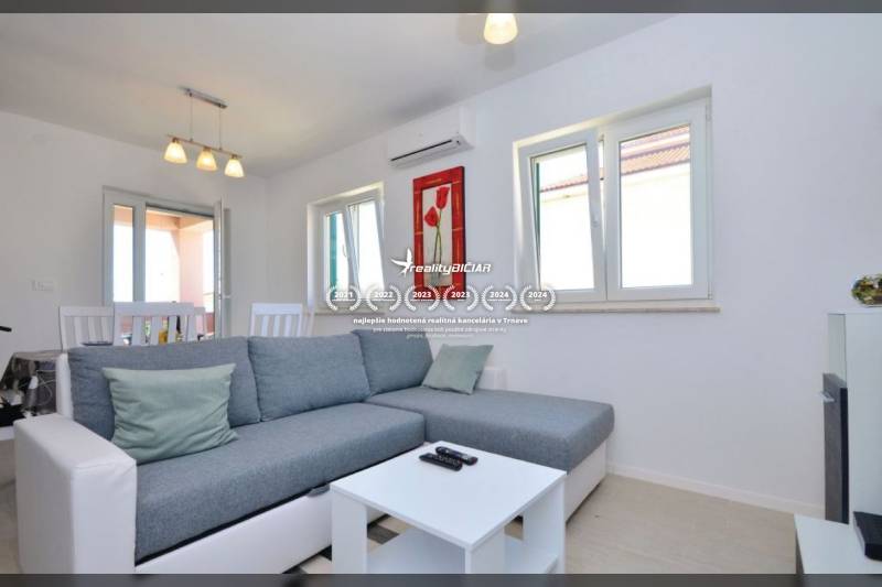 Wohnzimmer mit grauem Sofa, Couchtisch und Esstisch in einer 2-Zimmer-Wohnung.