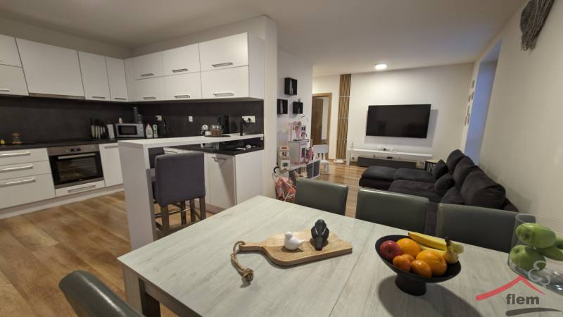 Küche mit Wohnzimmer in einer 2-Zimmer-Wohnung, helle Küchenzeile, Boden mit Holzdekor.