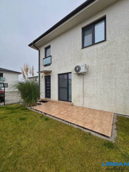 Eine 3-Zimmer-Wohnung in Kráľovianky hat eine Terrasse und eine Rasenfläche mit einer grauen Fassade.