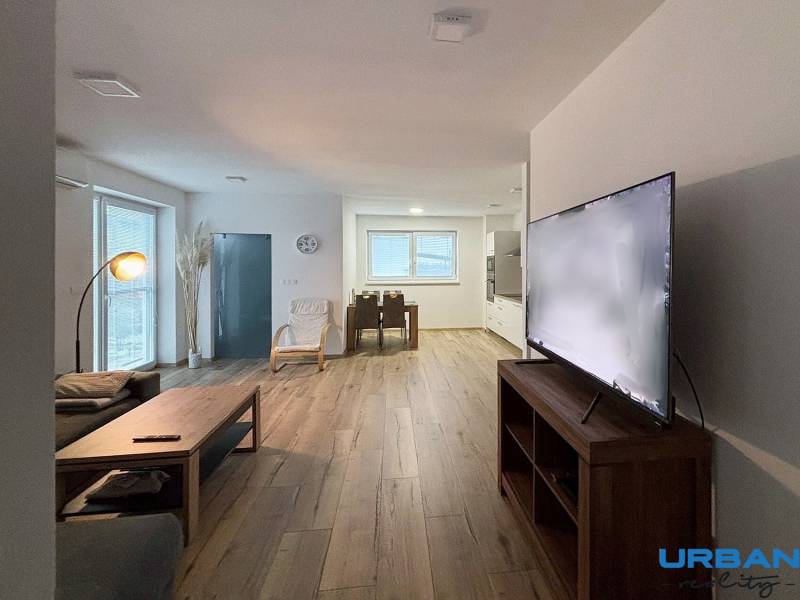 Wohnzimmer in einer 3-Zimmer-Wohnung mit Sofa, Fernseher und Boden in Holzoptik.