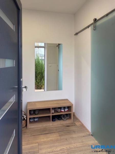 3-Zimmer-Wohnung mit Schuhbank, Spiegel und Boden in Holzoptik.