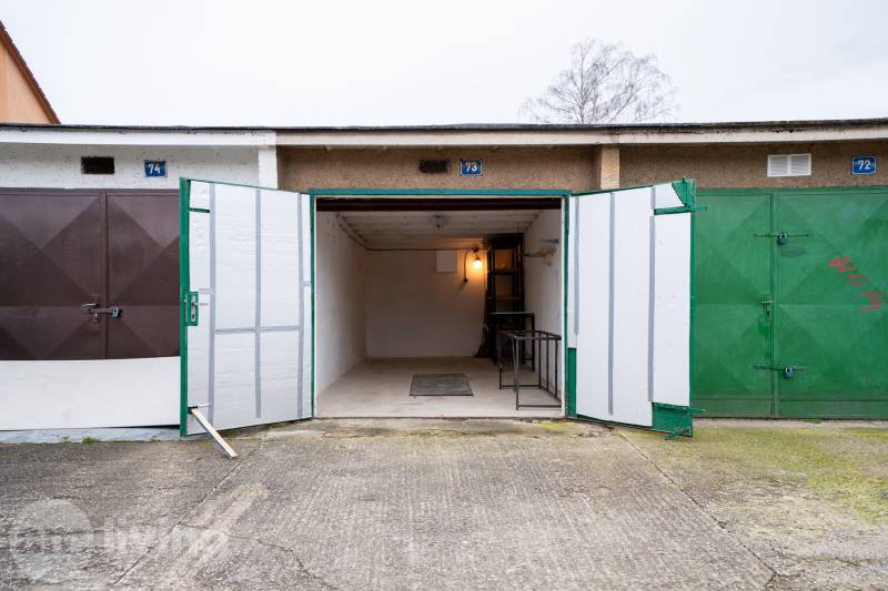 Offene Garage in der Inovecká-Straße in Trenčín mit Innenbeleuchtung und Regalen.