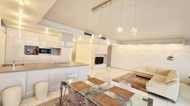 Ein geräumiger Wohnbereich in einer 3-Zimmer-Wohnung mit Küche, Esstisch und bequemer Couch.