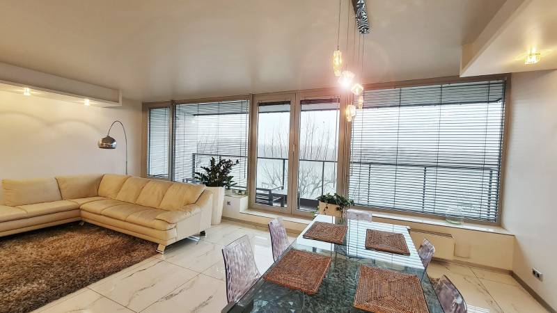 Wohnzimmer in einer 3-Zimmer-Wohnung mit heller Couch, Tisch und Glastüren.