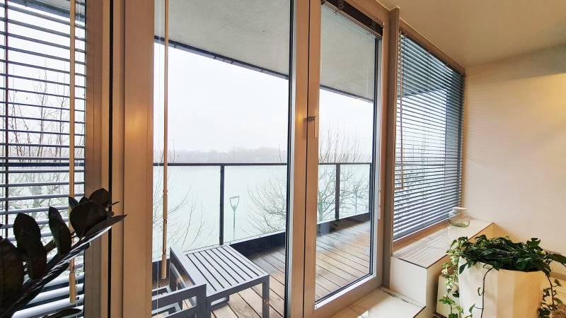 Balkon mit Blick auf den Fluss, Glastüren, Boden mit Holzdekor.