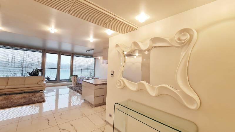 Luxuriöses Interieur einer 3-Zimmer-Wohnung mit großen Fenstern und stilvollem Spiegel.