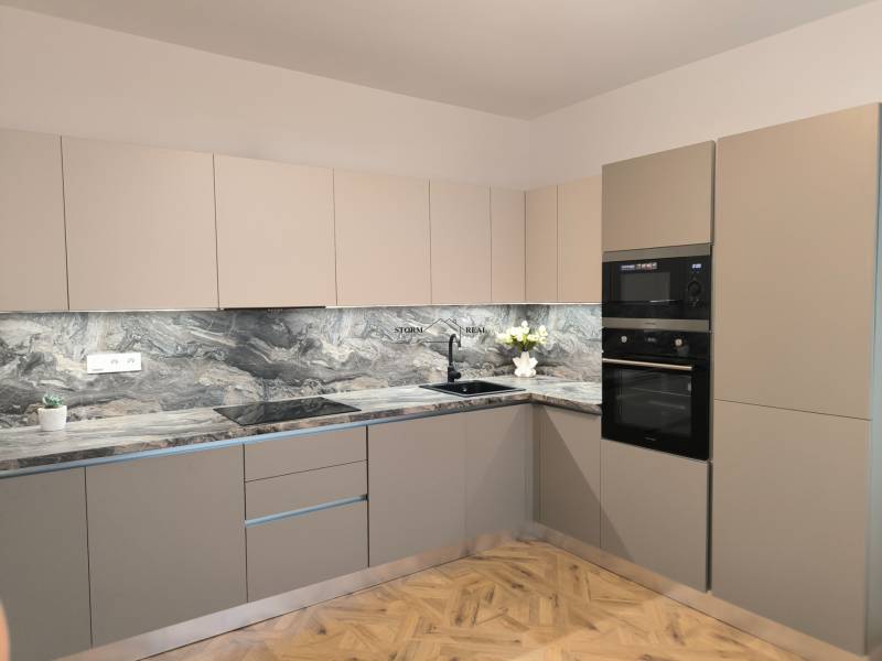 Küche in einer 4-Zimmer-Wohnung mit einer Marmor-Arbeitsplatte und einem Boden in Holzoptik.