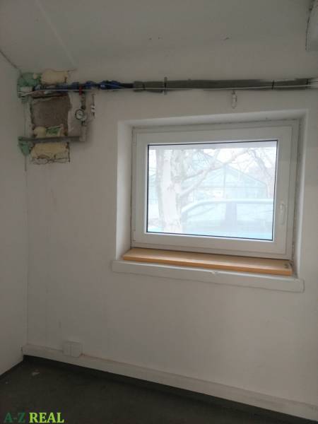 Ein Raum mit einem Fenster und einem Rohr an der Wand in einem Produktionsbereich.