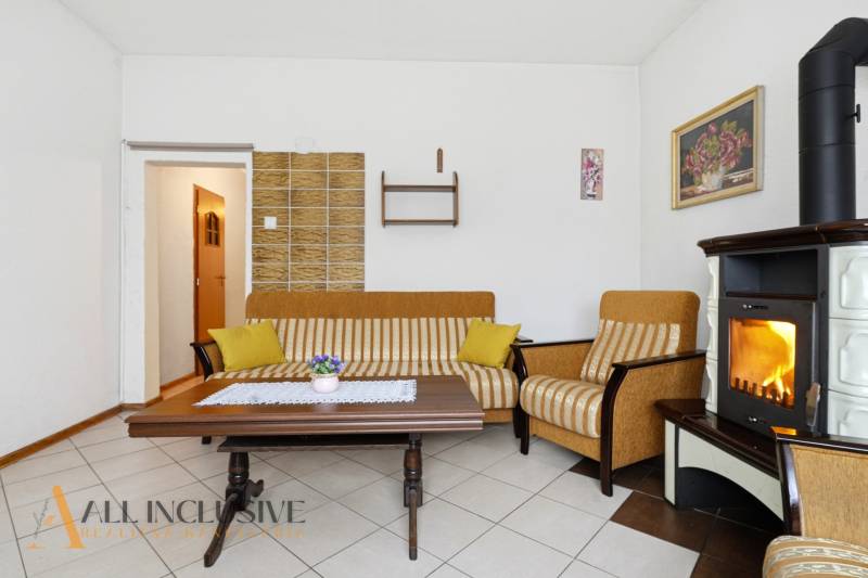 Wohnzimmer in einem Einfamilienhaus mit Kamin, gestreiftem Sofa und Couchtisch.