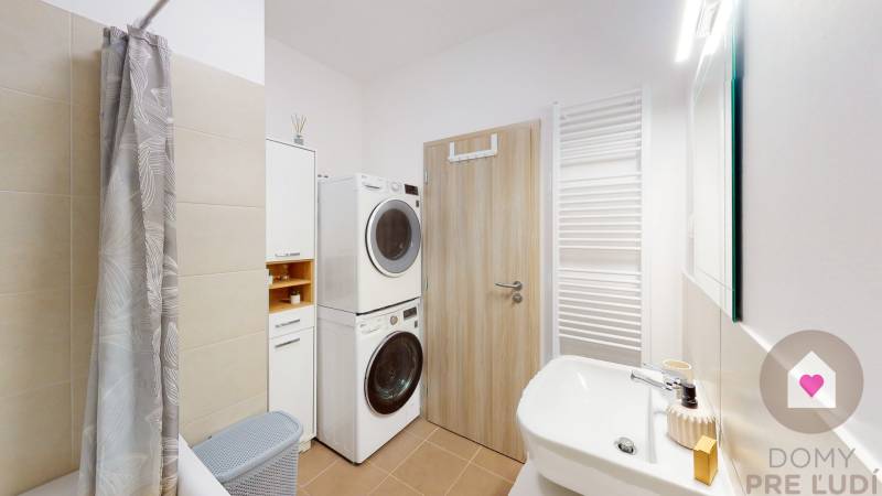 Badezimmer in einer 3-Zimmer-Wohnung mit Waschmaschine, Trockner und Duschvorhang.
