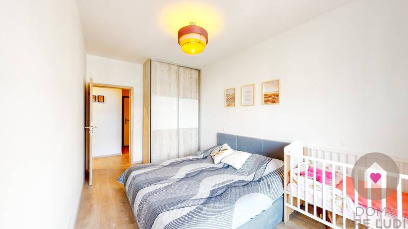 Schlafzimmer in einer 3-Zimmer-Wohnung mit Bett, Kinderbett und Schrank.